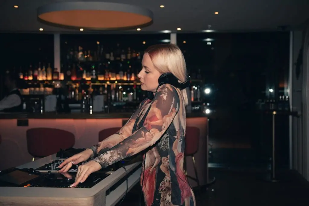 DJ mixing tracks at Perola cocktail bar Battersea with stylish backlit bar