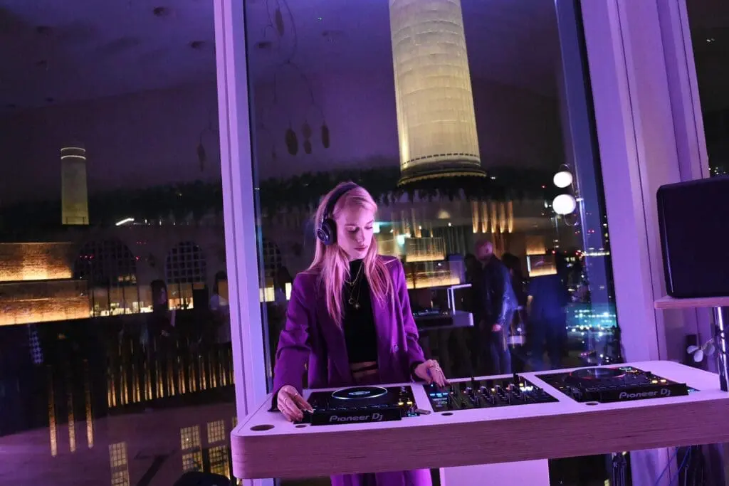 DJ performing at rooftop bar Perola Battersea Power Station with city view