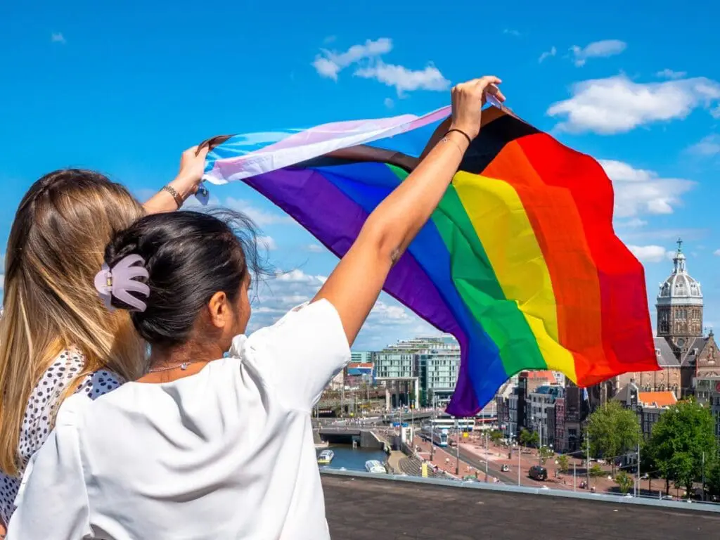 Two women waving a pride flag