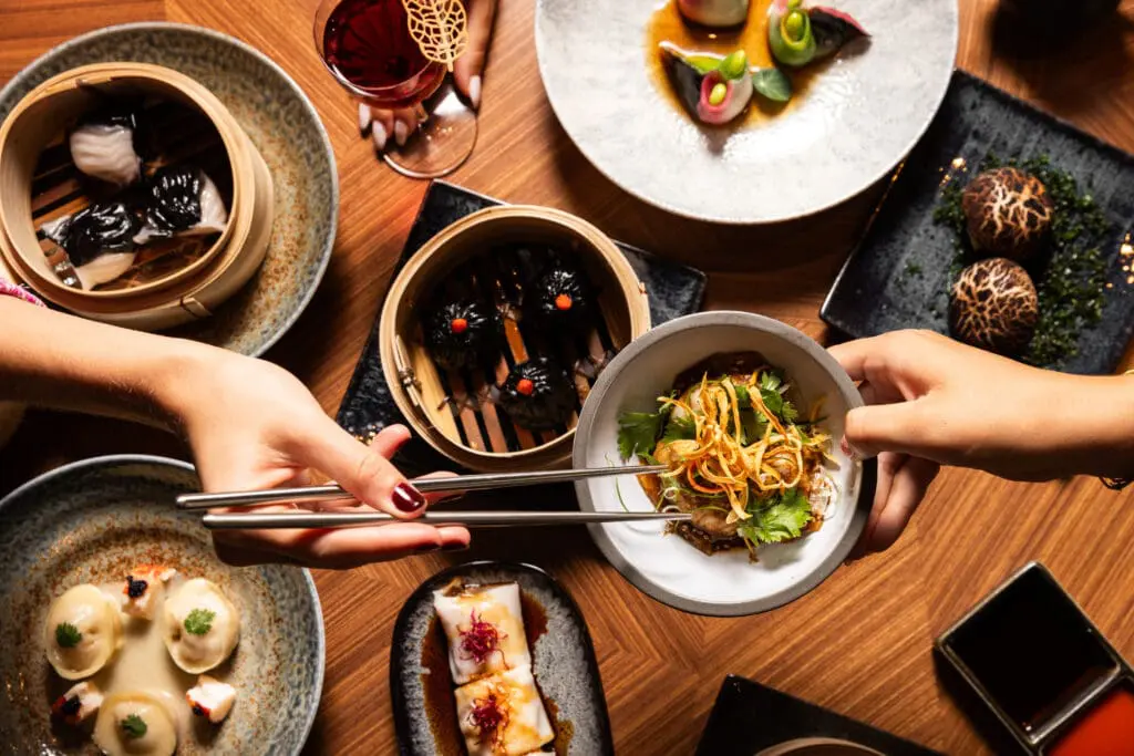 Two people sharing plates of dim sum at Yezi