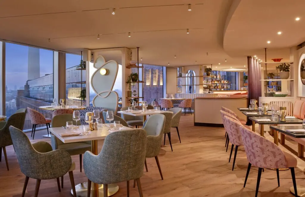 Elegant dining space at the art'otel Battersea Power Station restaurant & bar featuring modern décor, soft lighting, stylish seating and panoramic city views.