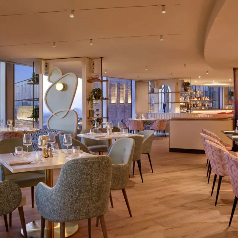 Elegant dining space at the art'otel Battersea Power Station restaurant & bar featuring modern décor, soft lighting, stylish seating and panoramic city views.