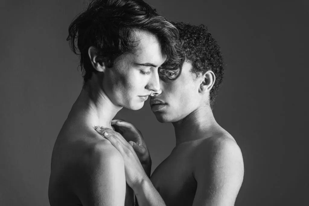 A black and white portrait of two nude women