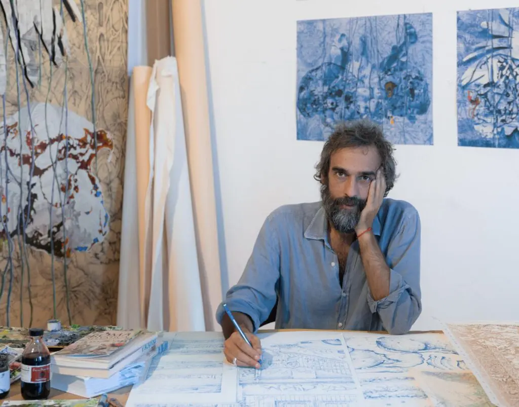 Pietro Ruffo sitting at a desk working on a picture