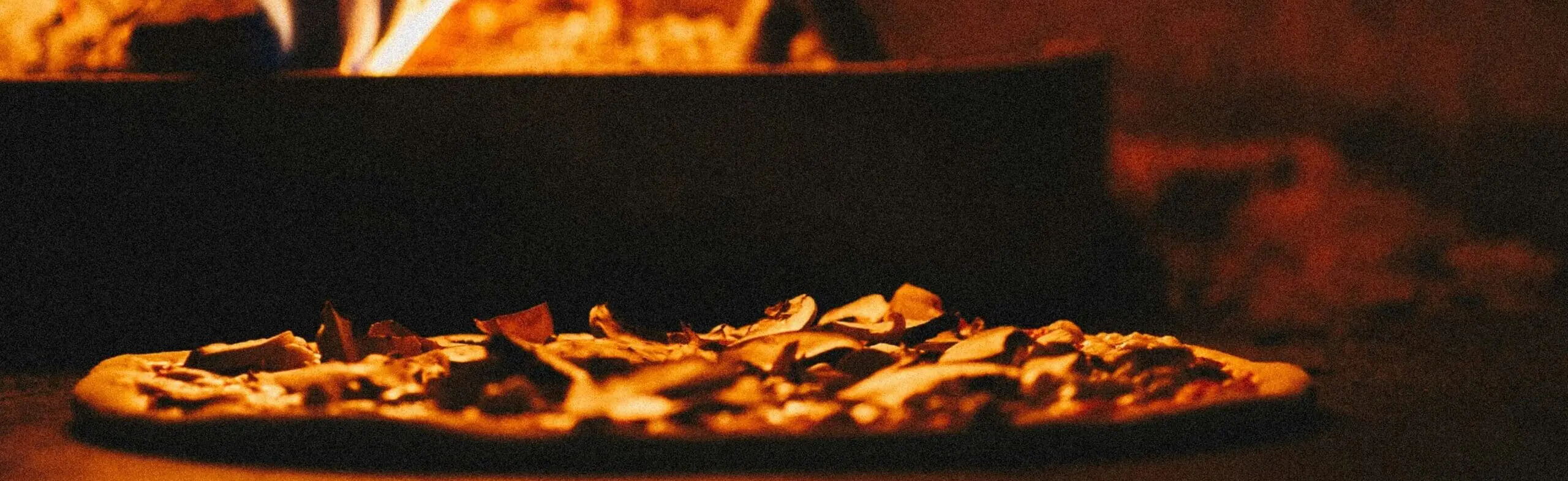 Pizza being cooking in a wood fire oven at a Restaurant in Rome, Italy.