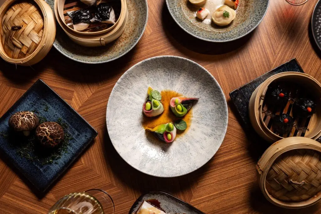 A collection of Dim Sum dishes being served on a wooden table at Yezi restaurant in Rome.
