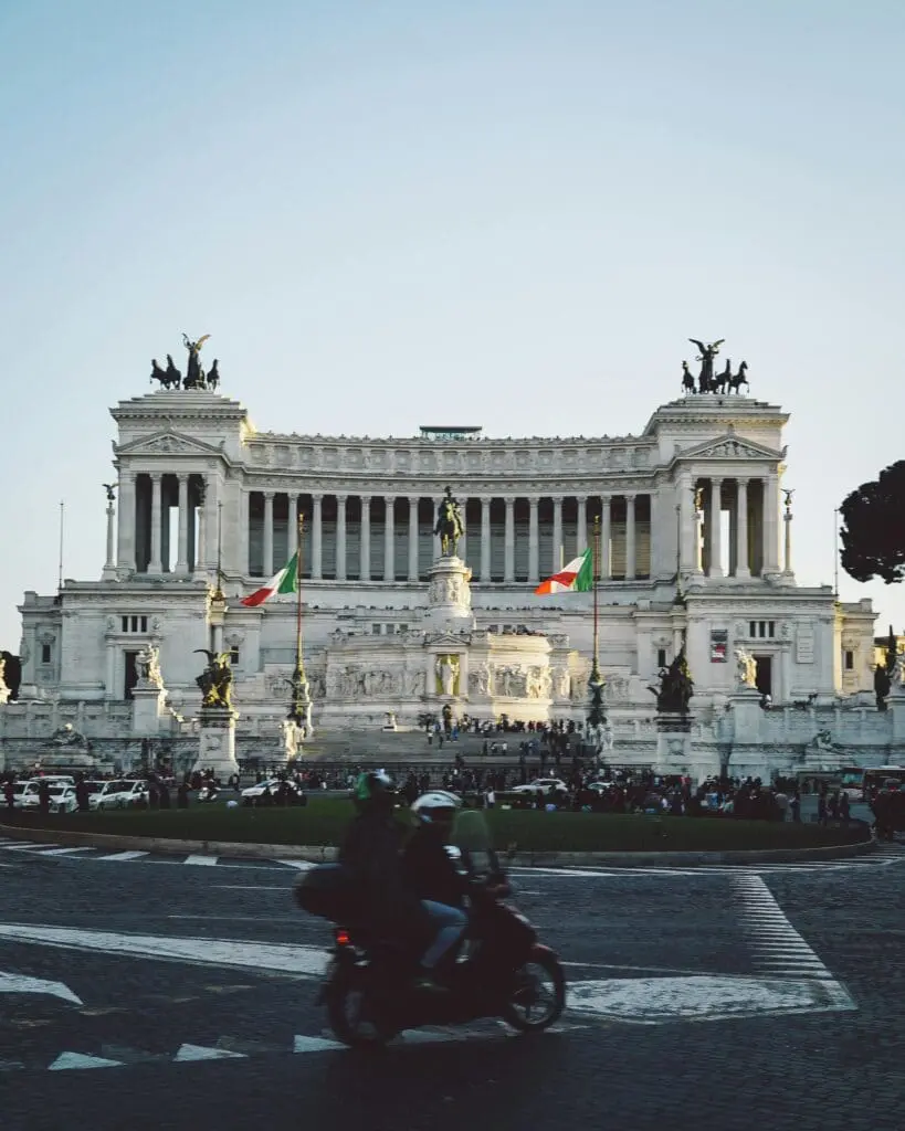 Two people on a moped outside Il Vittoriano in Rome, Italy
