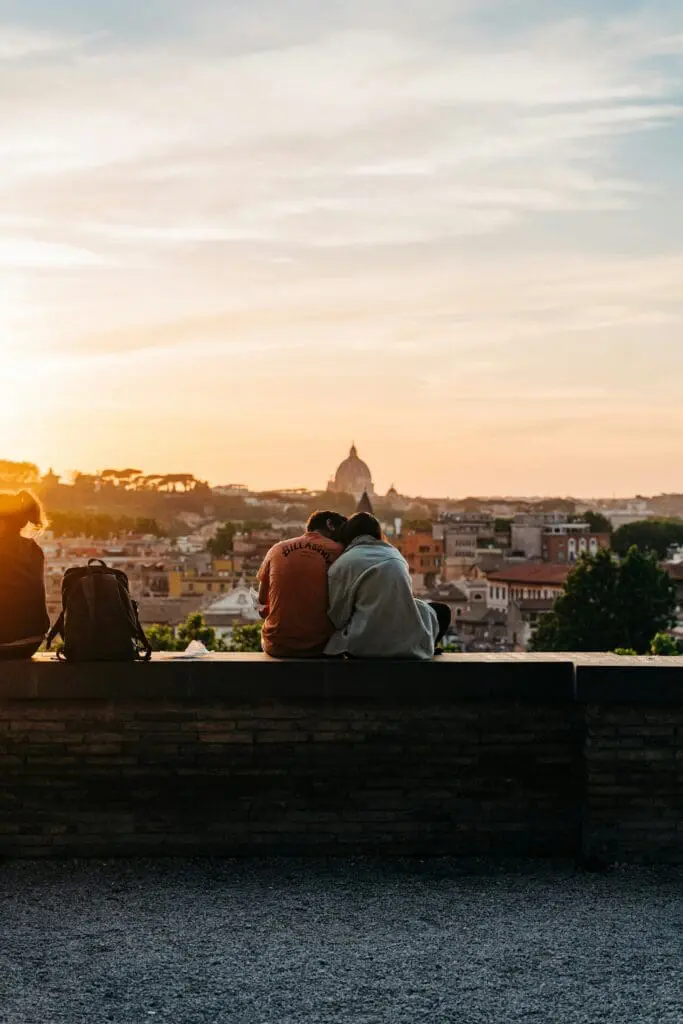 Two people sitting on Janiculum Hill in Rome, Italy, watching the sunset.