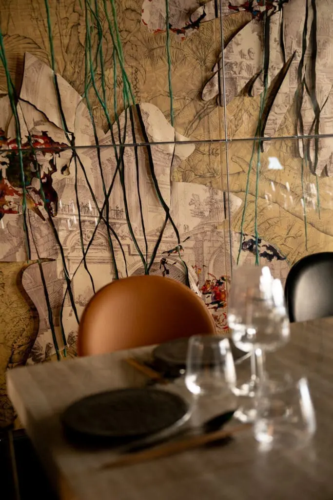 Artistic wall mural with intricate architectural sketches and abstract lines at art gallery art'otel hotel Rome dining area.