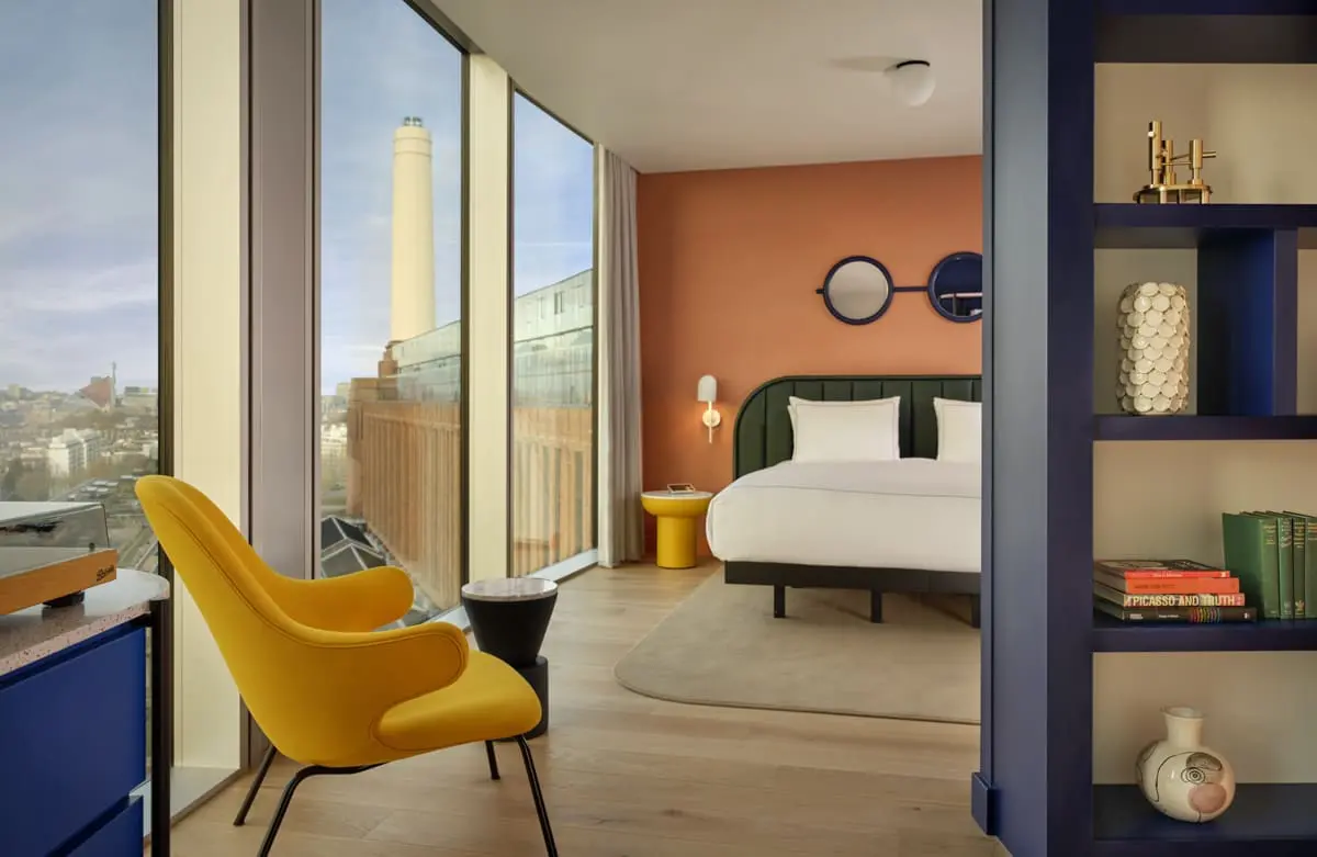 Stylish Battersea Power Station view room at art'otel featuring modern design, large windows, vibrant decor, and cozy seating.
