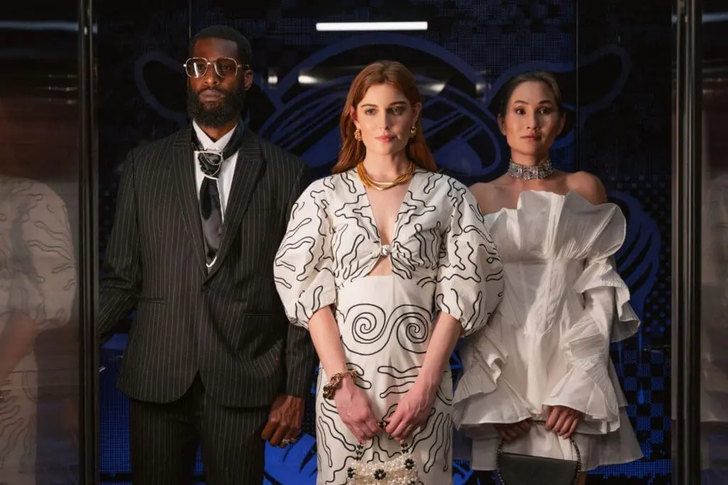 Three individuals wearing elegant high-fashion outfits at art'otel London Hoxton Old Street hotel with pool