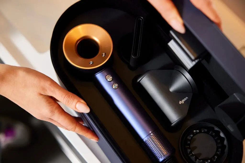 Hands holding a storage case with a Dyson hair dryer set at art’otel Rome.