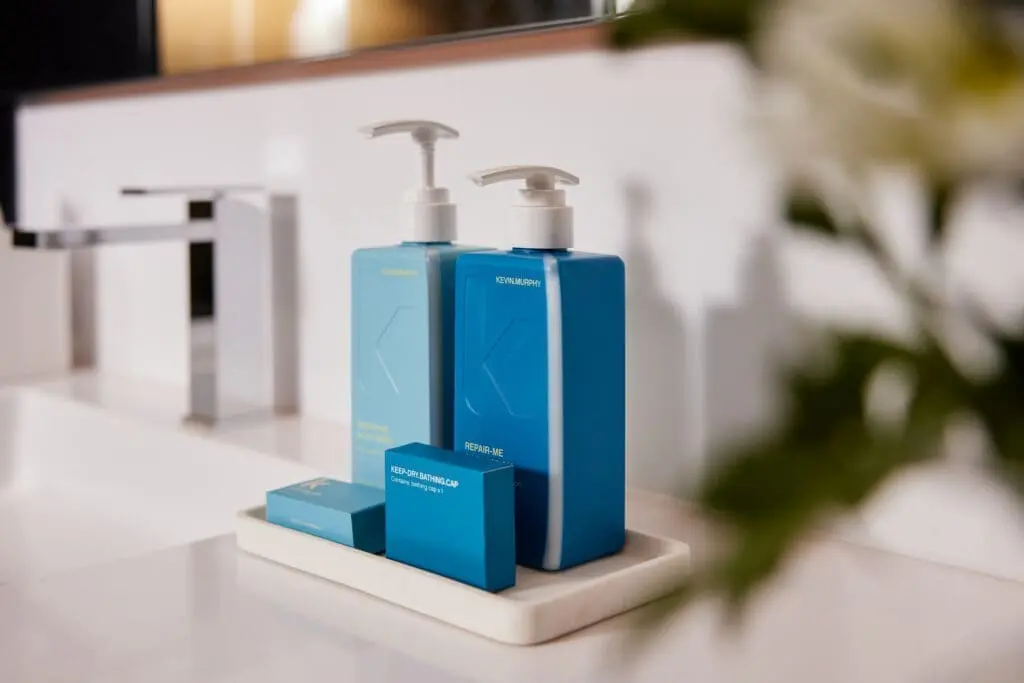 Bathroom amenities at art’otel Rome art hotel featuring blue Kevin Murphy shampoo, conditioner, and soap set.