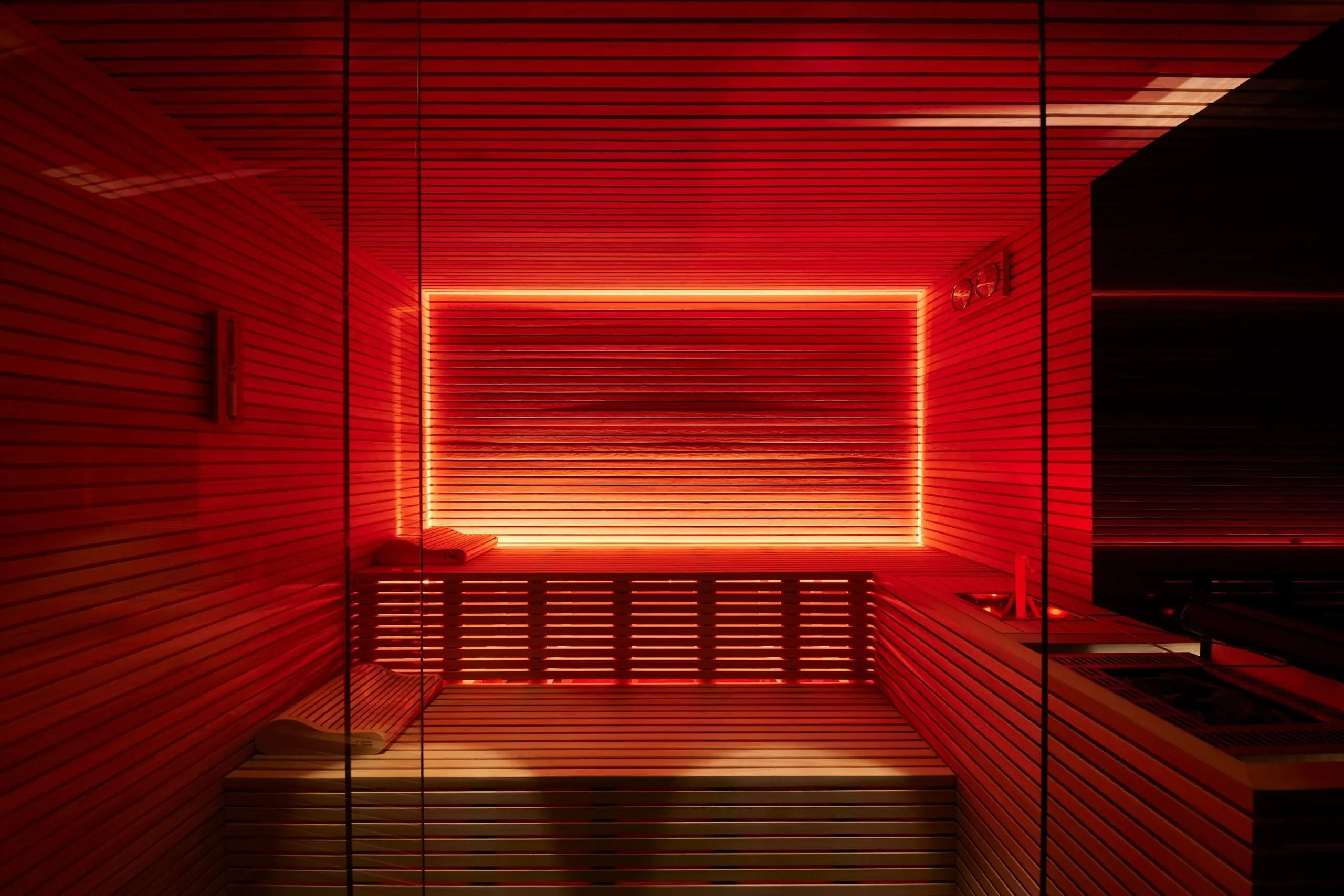 Modern sauna with warm red ambient lighting at art'otel Luxury art hotel Rome.