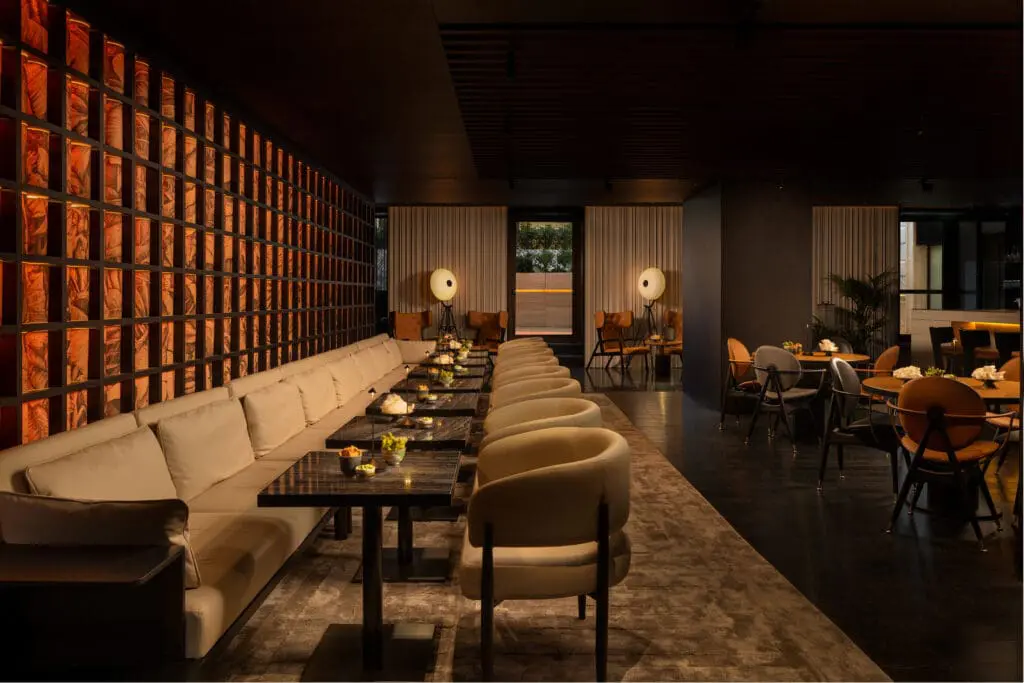 Elegant indoor seating at art'otel Yezi restaurant Roma with modern lighting, stylish chairs, and warm artistic wall design.