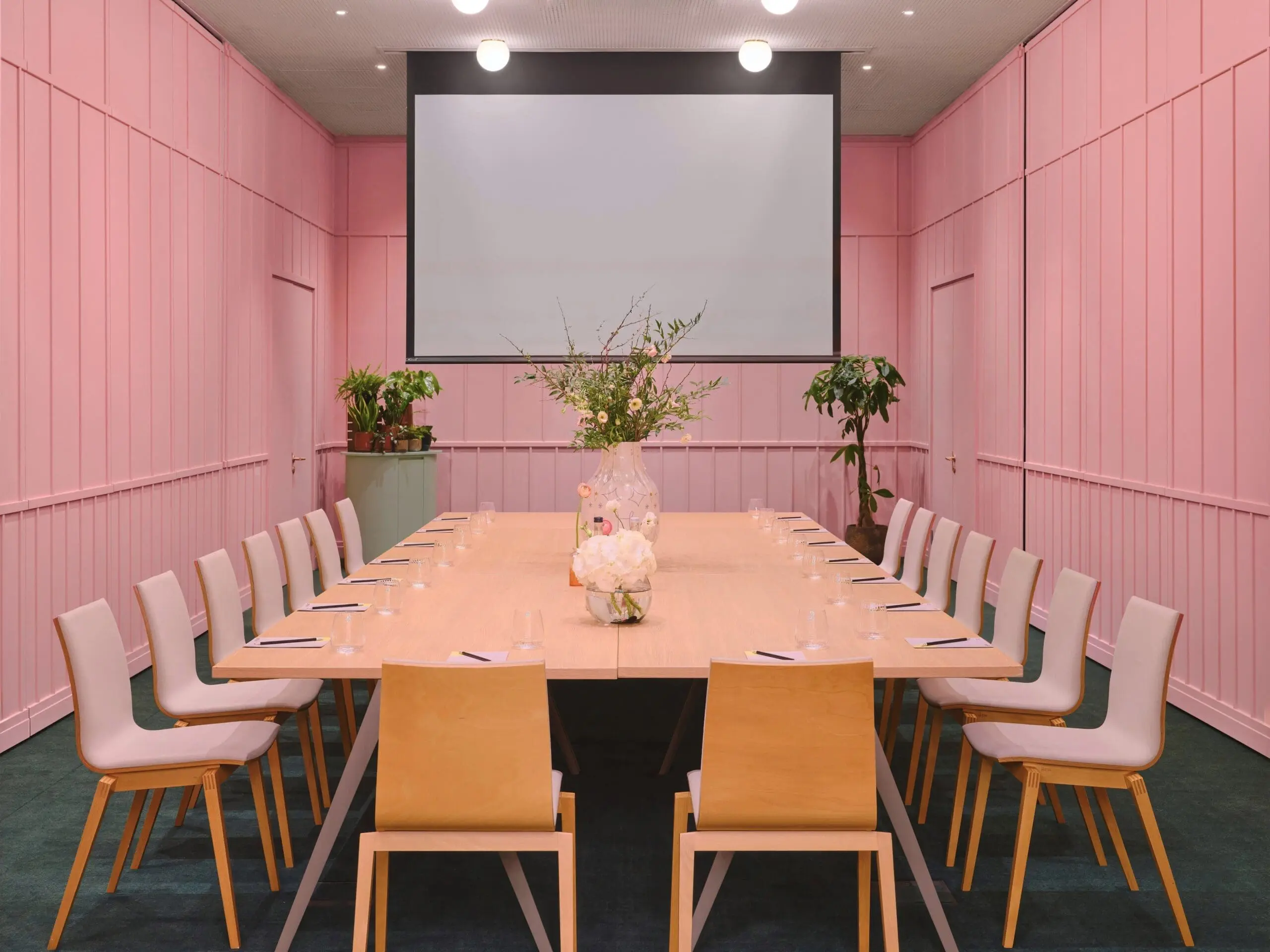 Stylish meeting room at art'otel Battersea Power Station meeting to hire featuring pink walls, modern table setup, and elegant decor.