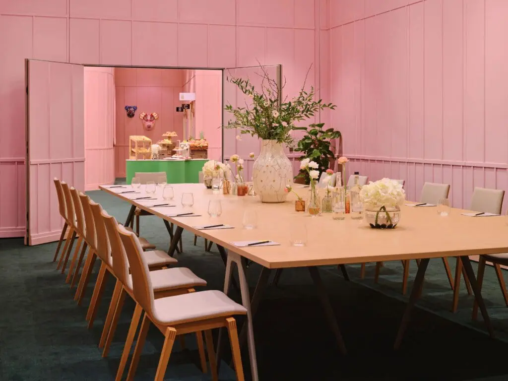Stylish meeting room at art'otel Battersea Power Station meeting to hire featuring pink walls, modern table setup, and elegant decor.