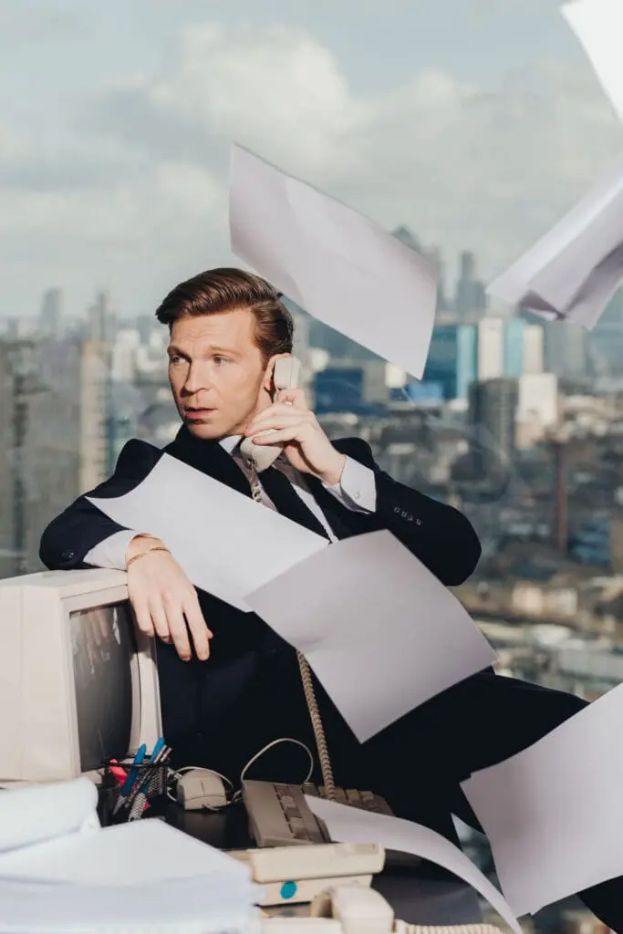 Person in business suit on phone with flying papers and city skyline view at art'otel London Hoxton
