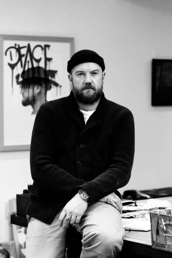 A D*Face wearing a black hat and black sweater at art'otel London Hoxton Old Street hotel with spa