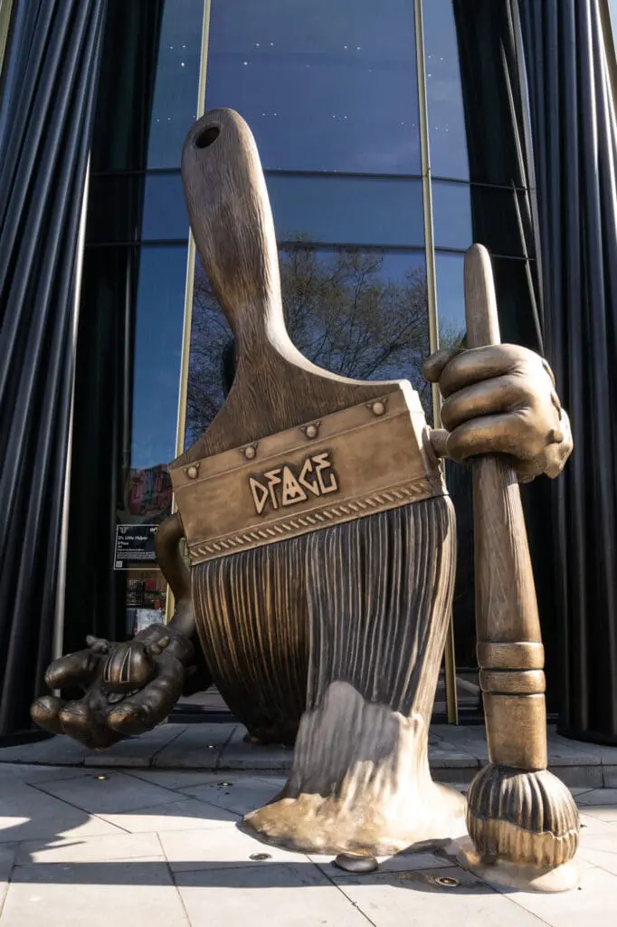 Large bronze paintbrush sculpture by D*FACE outside art'otel London Hoxton Shoreditch hotel.