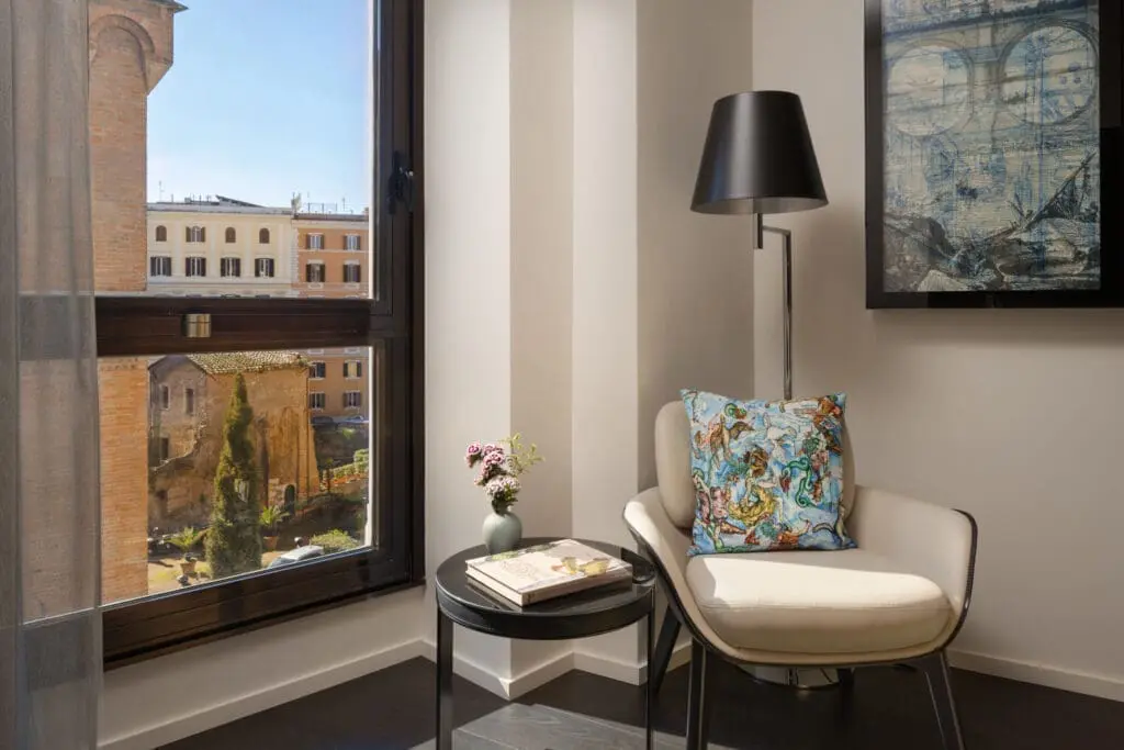 Cozy reading corner with city view at art'otel Luxury art hotel Rome.