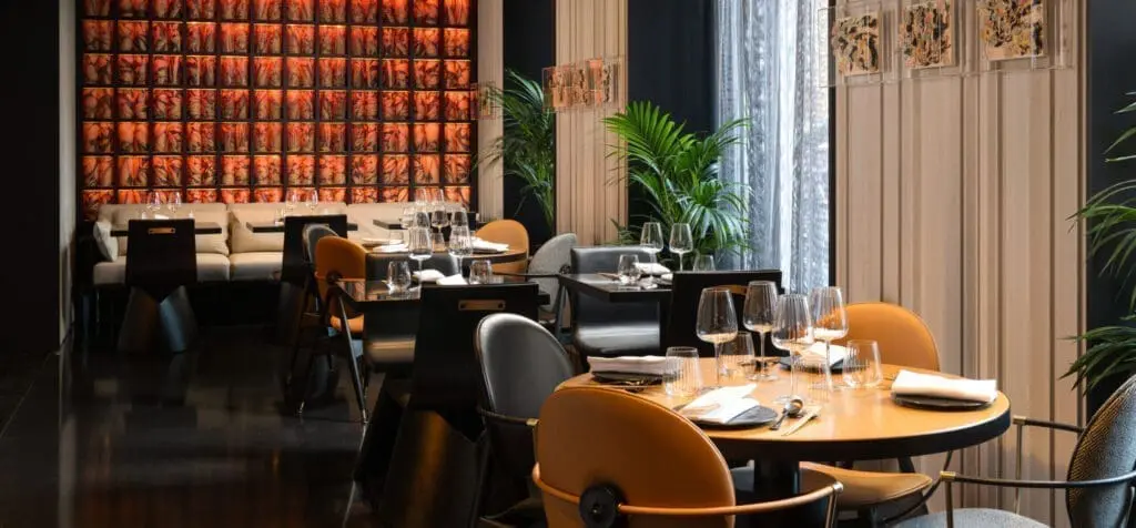 Modern dining area at art'otel Luxury art hotel Rome featuring stylish tables, elegant glassware, and vibrant artistic wall design.