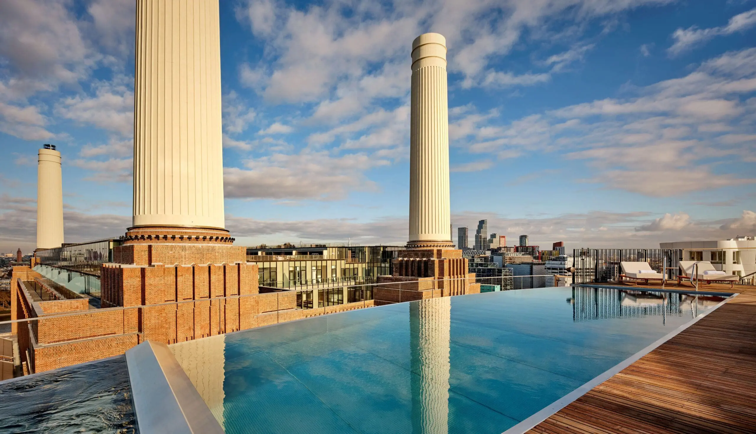 Rooftop infinity pool at art’oetl Hotel with pool near Battersea Power Station offering stunning skyline views and modern deck seating on a sunny day.