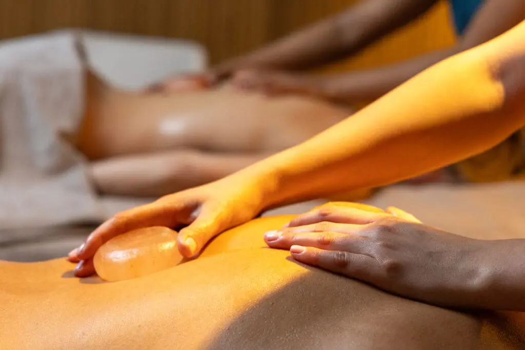 Close-up of a relaxing back massage in a luxury spa at art'otel London Hoxton Shoreditch hotel with spa, featuring warm ambient lighting.