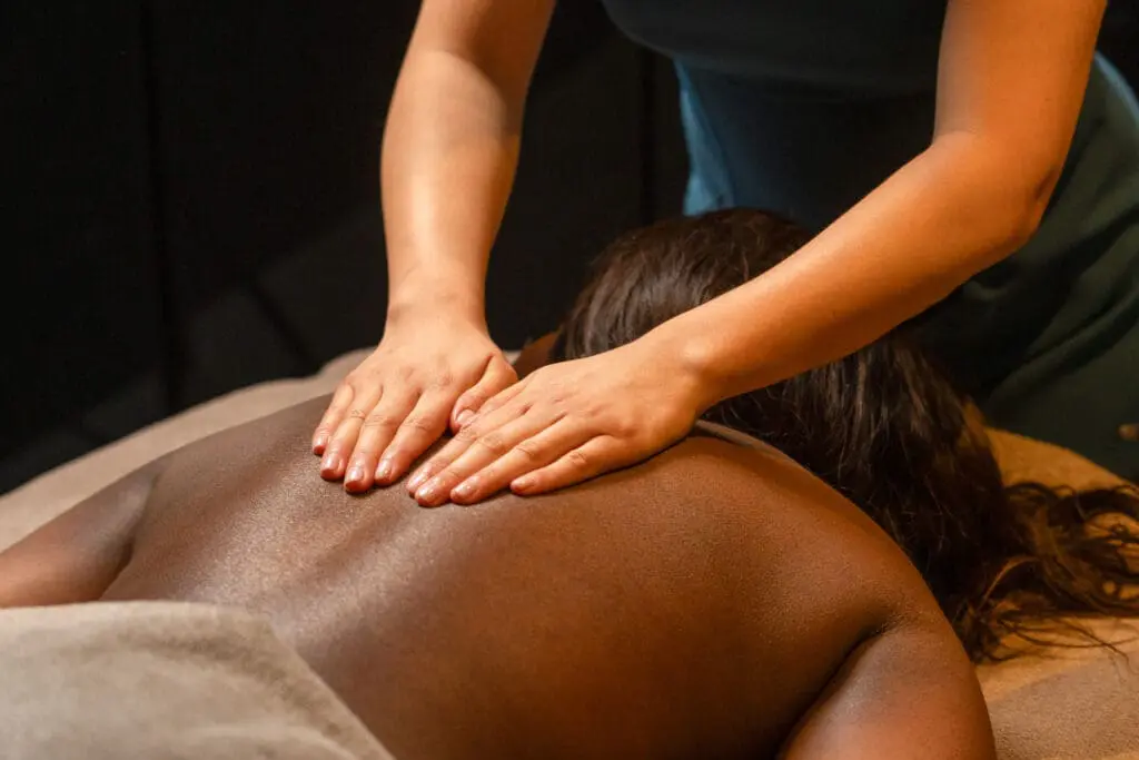 Close-up of a relaxing back massage in a luxury spa at art'otel London Hoxton Shoreditch hotel with spa, featuring warm ambient lighting.