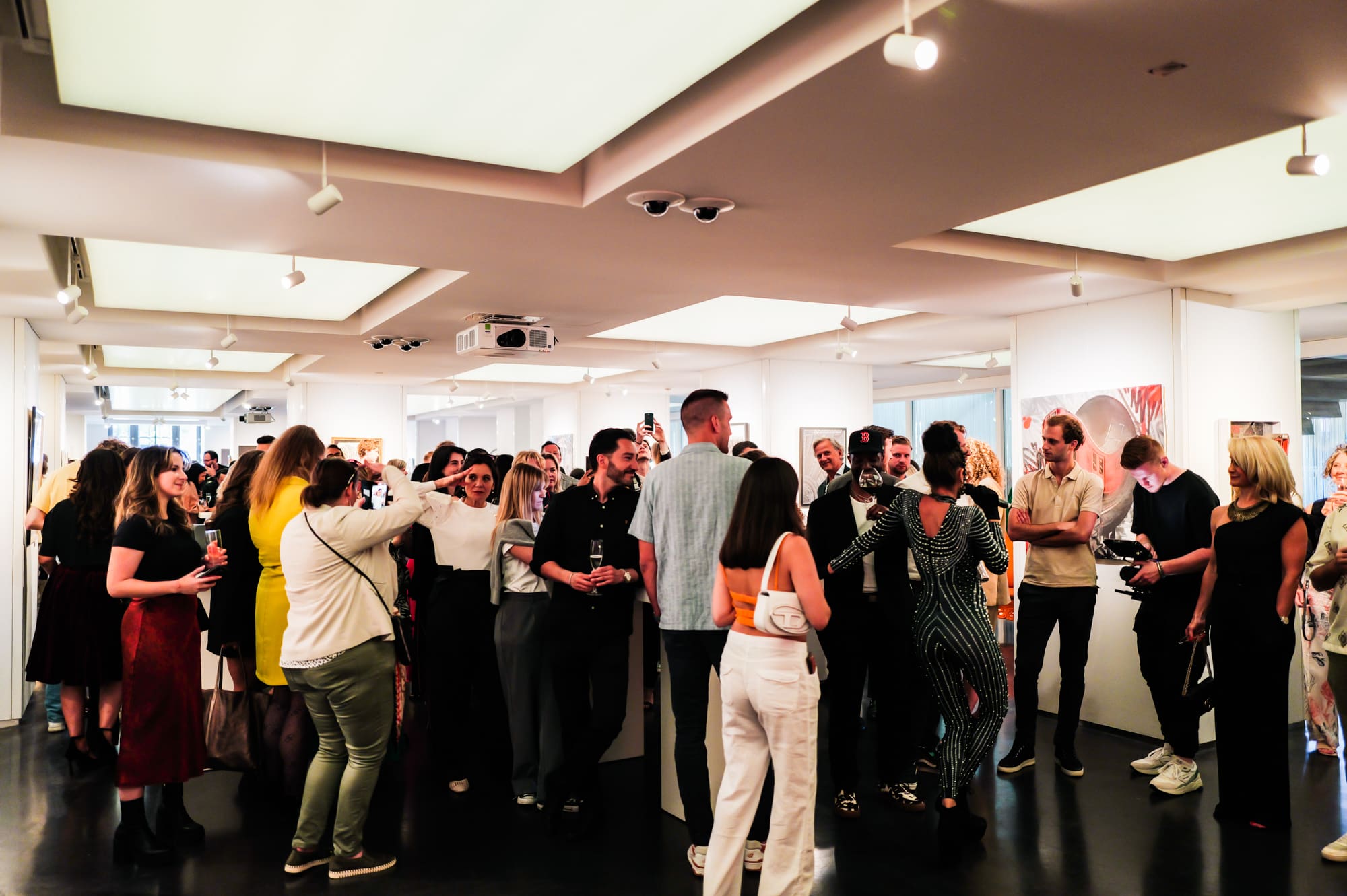 a group of attendees stand in the art'otel Amsterdam gallery for an event