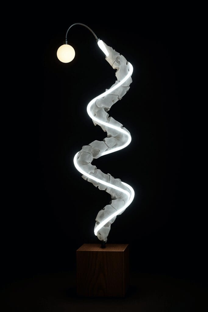 Abstract spiral sculpture with glowing light displayed at art exhibition Shoreditch.